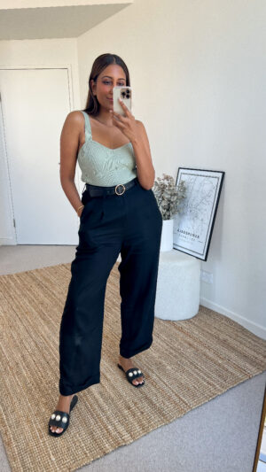 Tina wears a sage crop top, black pants styled with her pearl trim slides
